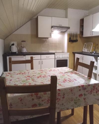 a kitchen with a table with a floral table cloth on it at Rooming Green mit Seeblick in Weyregg