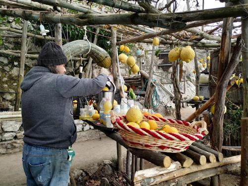 a man is standing next to a basket of fruit at Ulisse sul Sentiero in Praiano
