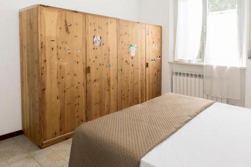 1 dormitorio con armario de madera y cama en P002 - Porto Recanati, trilocale a due passi dal mare en Porto Recanati