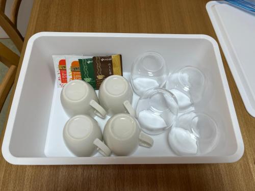 a white tray filled with white cups and spoons at 日田ホステル　Hita Hostel in Hita