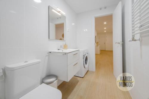 een witte badkamer met een wasmachine en een wastafel bij Smart Apartment 3pax en Madrid Rio con Parking in Madrid