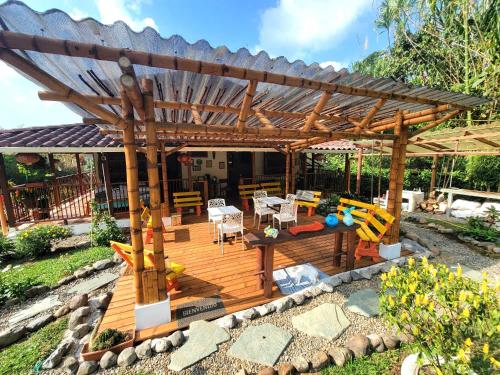 una terraza de madera con pérgola de madera en PaloSanto, Casa Rural, en Jardín