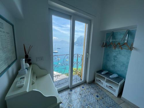 a room with a large glass door with a view of the ocean at La Terrazza sul Mare in Capri
