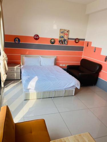 a bedroom with a bed and a chair at Aliya阿利亞 in Huwei