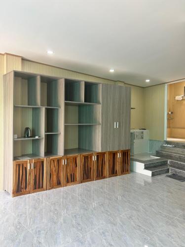 Long KhanhにあるMotel Khánh Võの木製の棚とキッチンが備わる広い客室です。