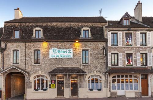 a large brick building with a sign on it at Hotel De La Cloche in Beaune