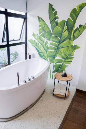 a bath tub in a bathroom with a large plant at Hotel Piedras De Maní in Manizales