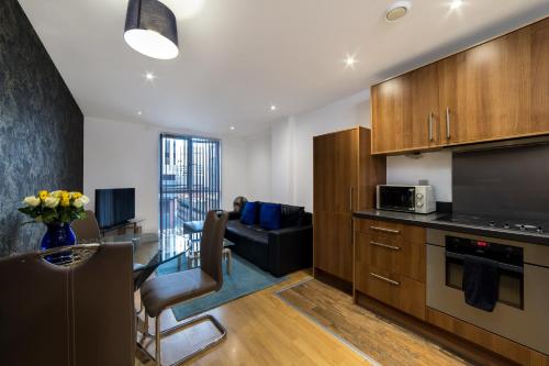 a kitchen and living room with a couch and a table at Cutlass Court Apartments by Comfort Zone in Birmingham