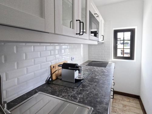 a kitchen with a black counter top and white cabinets at MoonLava: Apto, Piscina, WiFi in Yaiza