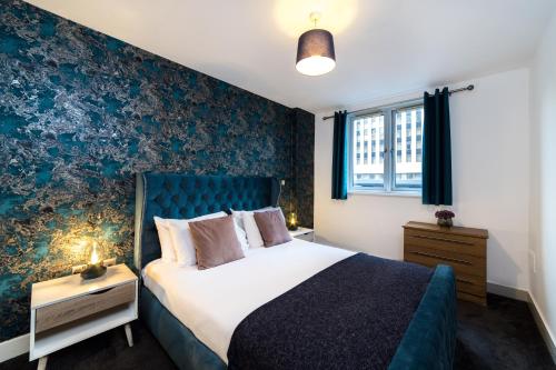 a bedroom with a bed and a blue wall at Cutlass Court Apartments by Comfort Zone in Birmingham