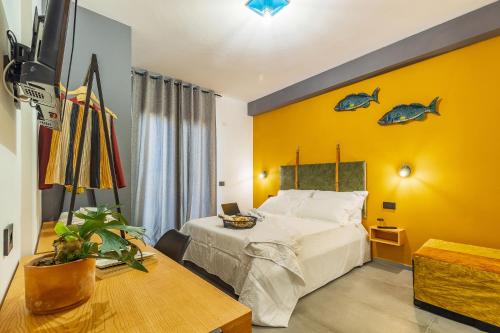 um quarto com uma cama e uma parede amarela em BB OgliastRoom em Tortolì