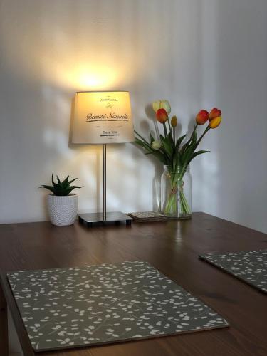 a table with a lamp and flowers on it at Pozlovice - Apartmán Sisi in Luhačovice