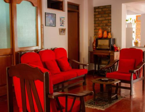 a living room with red chairs and a red couch at Yoly's House in Caraz