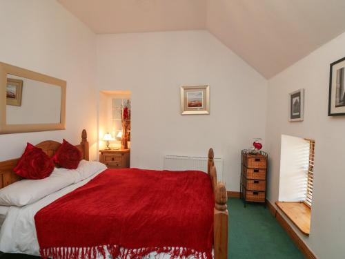 a bedroom with a bed with a red blanket at The Abraham in Moone