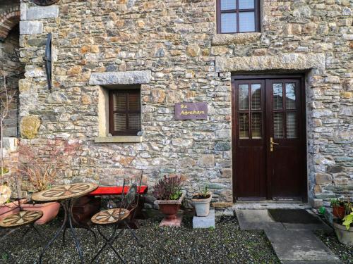 a stone building with a door and a table and chairs at The Abraham in Moone