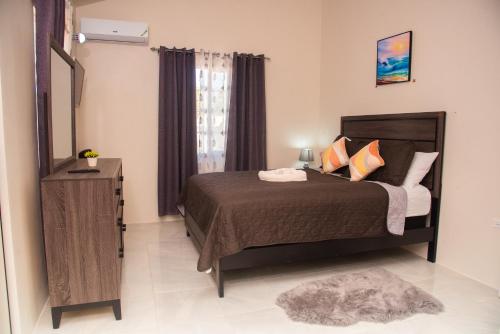 a bedroom with a bed and a mirror at Oceanview Jamaica in Discovery Bay