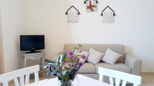 Villa Contessina في Cossignano: غرفة معيشة مع أريكة وطاولة مع زهور