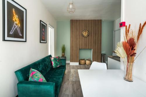 uma sala de estar com um sofá verde e uma mesa branca em Shoreditch-bricklane-convenient-central-liverpoolstreet em Londres
