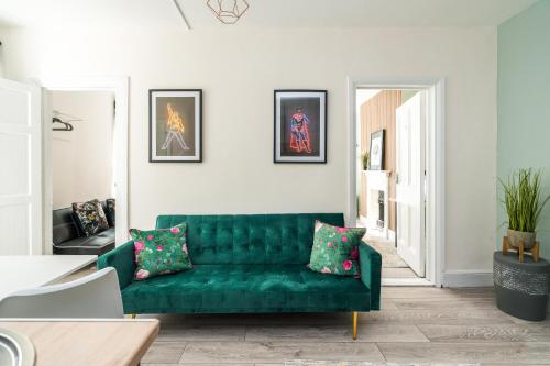 uma sala de estar com um sofá verde num quarto em Shoreditch-bricklane-convenient-central-liverpoolstreet em Londres