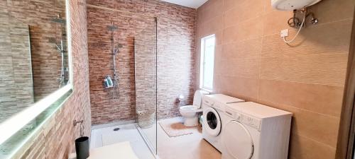 a bathroom with a toilet and a washing machine at Seaside Serenity - Luxe Penthouse - near the beach by QuickTrips in Mellieħa