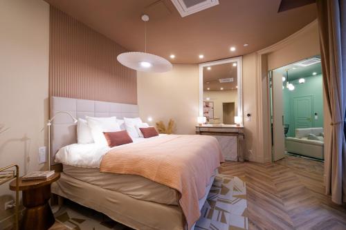 une chambre avec un grand lit et une salle de bain dans l'établissement WS Louvre - Saint-Roch Luxe, à Paris