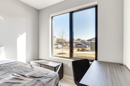 um quarto com uma cama e uma grande janela em Modern Bloomington Apt Near Indiana University! em Bloomington