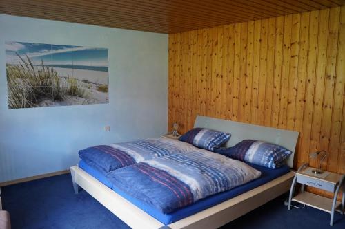 a bedroom with a bed with a wooden wall at Pension Klier in Hohenwarth