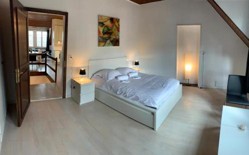a bedroom with a bed with two lamps and a staircase at Superbe Duplex Vue Château et Lac in Neuchâtel