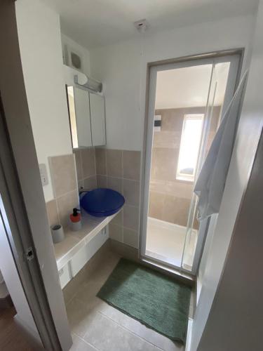 a bathroom with a shower and a blue toilet at Quiet cosy 1 bedroom apartment Carrington F1 in Nottingham