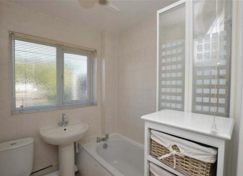 Cosy & Peaceful 3B Home in Sandridge, St Albans في سانت ألبانز: حمام أبيض مع حوض ومرحاض
