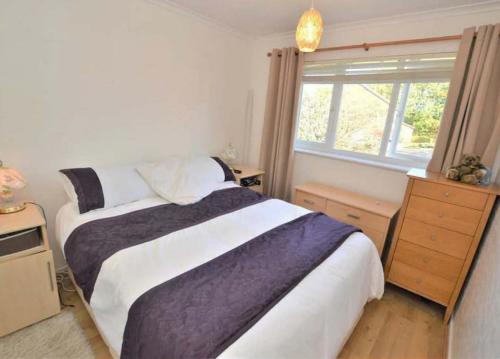 Cosy & Peaceful 3B Home in Sandridge, St Albans في سانت ألبانز: غرفة نوم بسرير كبير ونافذة