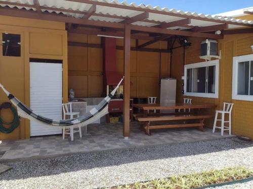 Casa de férias familiar com linda vista à 300m da Meia Praia de Navegantes في نافيغانتس: شرفة منزل مع أرجوحة وطاولة
