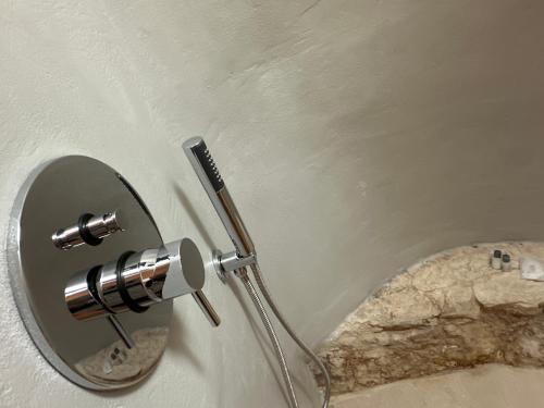 a mirror on a wall next to a rock at Arquati room in Ostuni