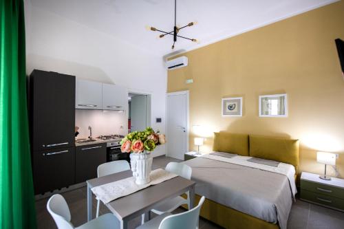 ein Schlafzimmer mit einem Bett und einem Tisch mit Blumen darauf in der Unterkunft Appartamenti vista mare Otranto in Otranto
