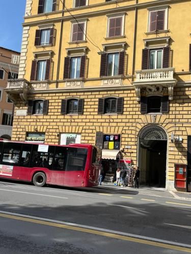 um autocarro vermelho estacionado em frente a um edifício em 163 BOUTIQUE HOTEL em Roma