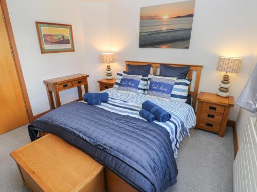 a bedroom with a blue bed with blue pillows at The Sail Loft in Milford Haven