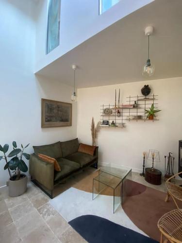 uma sala de estar com um sofá e uma mesa de vidro em Maison de ville atypique avec terrasse et poêle em Fontenay-sous-Bois