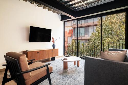 a living room with a tv and a couch at Urban Reforma Mexico City by Lumina in Mexico City