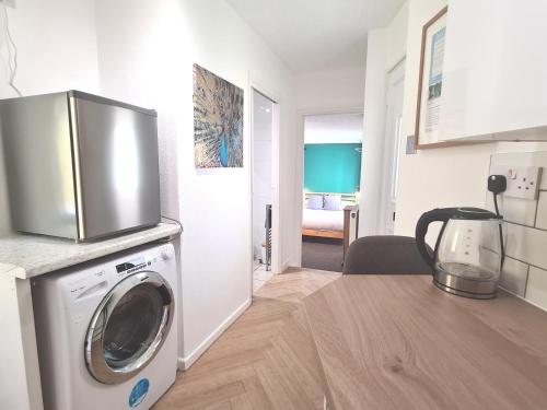 a kitchen with a washing machine with a microwave at Five-star apartment in London