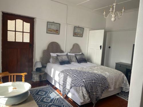 a bedroom with a bed and a table and a door at CasaMia in Bredasdorp
