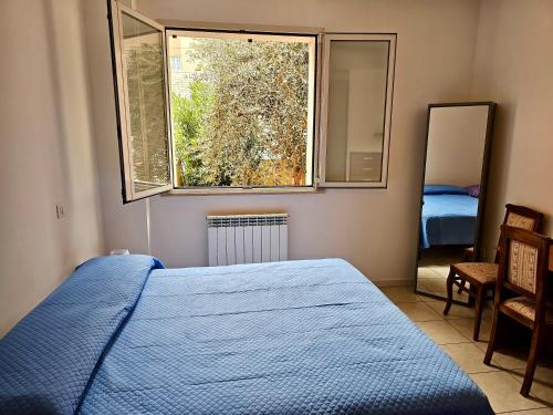 sypialnia z niebieskim łóżkiem i oknem w obiekcie SE052 - Marotta, delizioso bilocale con giardino w mieście Marotta