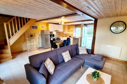 un salon avec un canapé bleu et une cuisine dans l'établissement Les Gîtes du Kokopelli : Yellowstone., à Plumelec