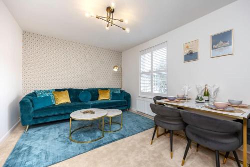 a living room with a blue couch and a table at Stunning modern space in Hove & free parking in Brighton & Hove