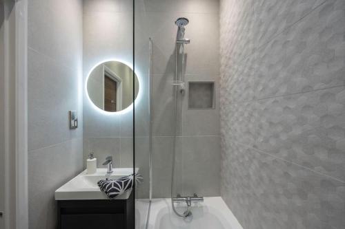 een badkamer met een douche, een wastafel en een spiegel bij Stunning modern space in Hove & free parking in Brighton & Hove