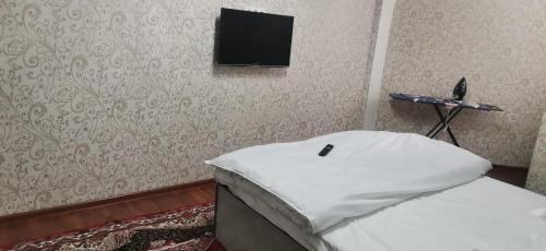a bedroom with a bed with a television on the wall at Your two-room apartment in Dushanbe in Dushanbe