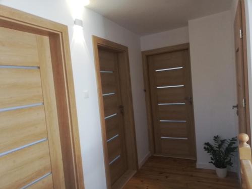 two doors in a room with white walls and wooden floors at Noclegi na 1 maja in Kielce