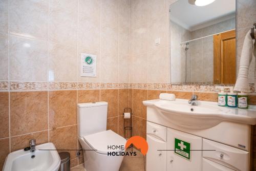 ein Badezimmer mit einem WC, einem Waschbecken und einem Spiegel in der Unterkunft #201 City View with Balcony and Pool in Albufeira