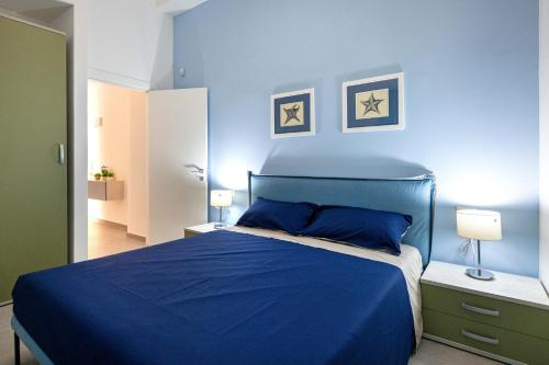a blue bedroom with a bed and two lamps at Appartamenti vista mare Otranto in Otranto
