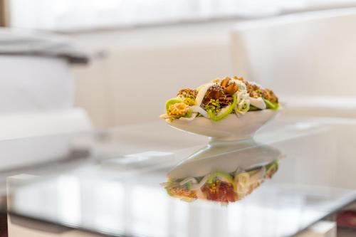 a vase filled with food on top of a glass table at Vila Jiřinka in Luhačovice