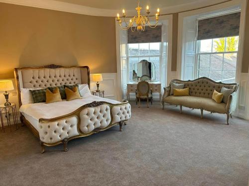 een grote slaapkamer met een groot bed en een bank bij The Tontine Hotel in Greenock